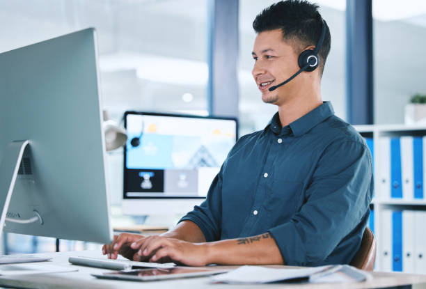 A man in front of a computer with a headset