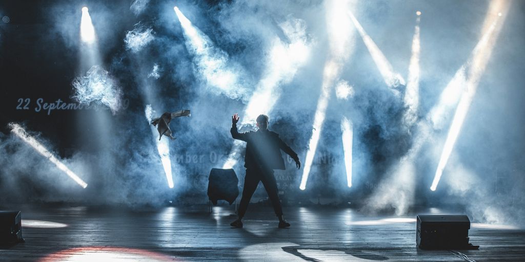 A man dancing on stage with stage lights