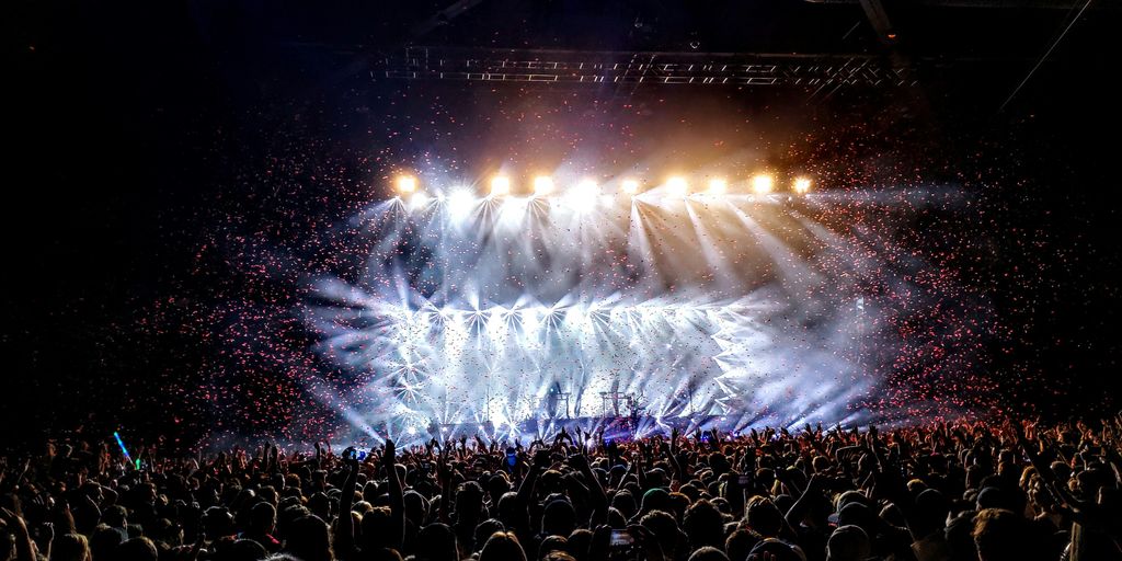 A concert stage with a lot of people watching