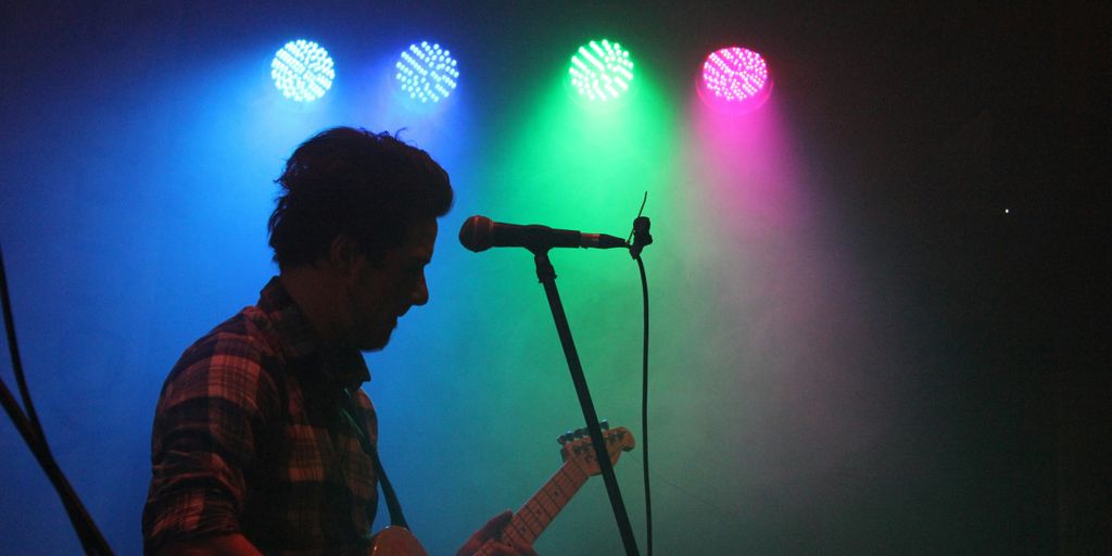 A man singing with stage lights