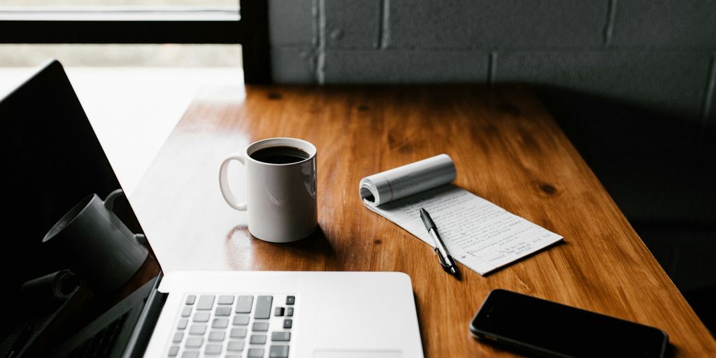 A laptop and coffee on a desk