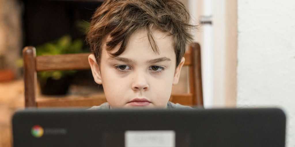 A little boy looking at a black monitor