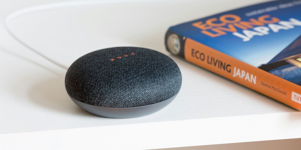 A black mini speaker beside a book