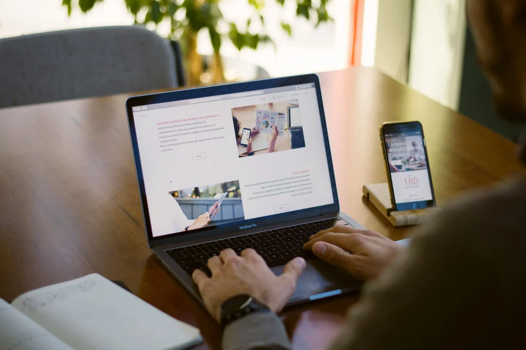 A laptop and smartphone with digital platforms, emphasizing multitasking or online project management.