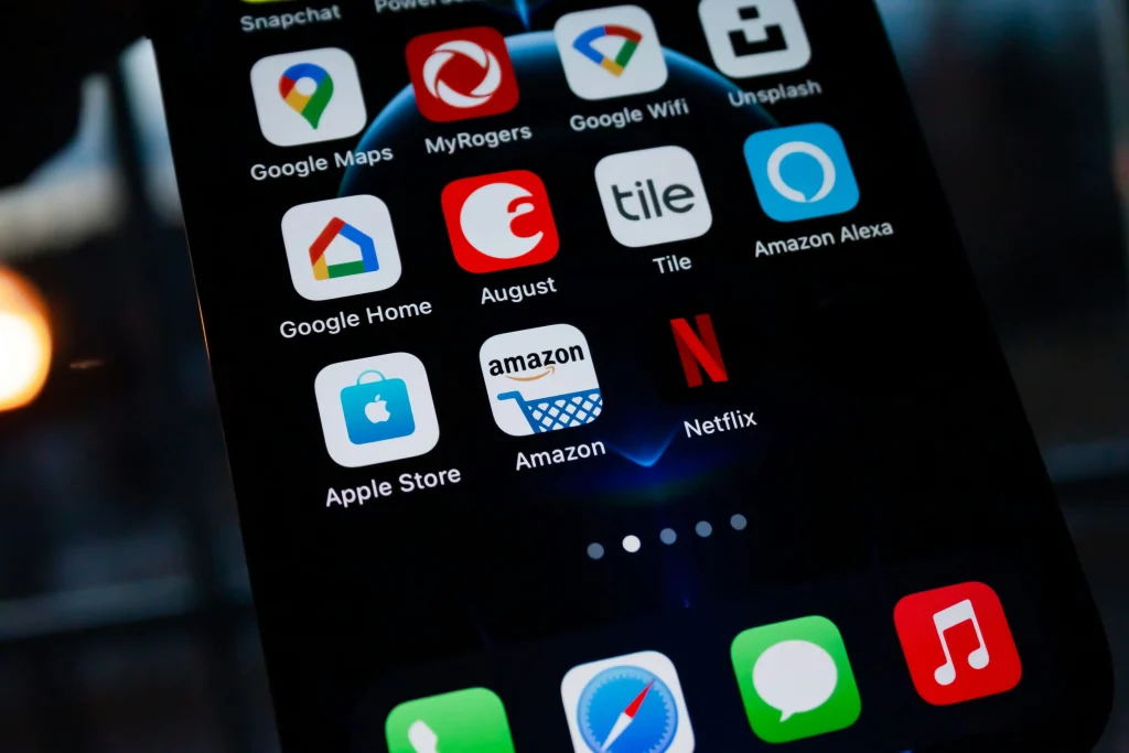 A close-up of a smartphone screen displaying popular app icons, including Amazon, Netflix, Google Maps, and Apple Store.
