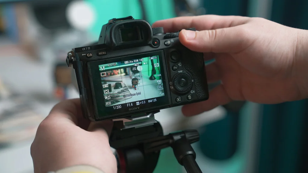 A person adjusting settings on a professional camera, possibly preparing for a photoshoot or video recording.