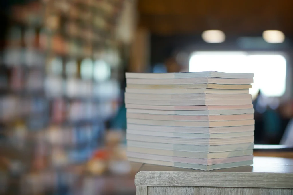 A stack of books or documents in a brightly lit office, representing organization or academic work.